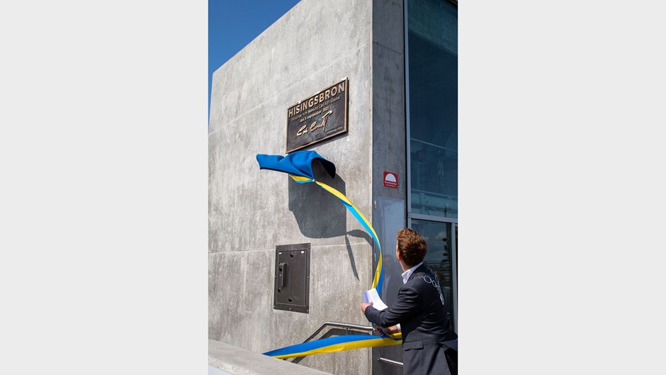 kynke dras bort av en man från en platta med Hans Majestät Konung Carl XVI Gustafs signatur som sitter på en betongvägg.