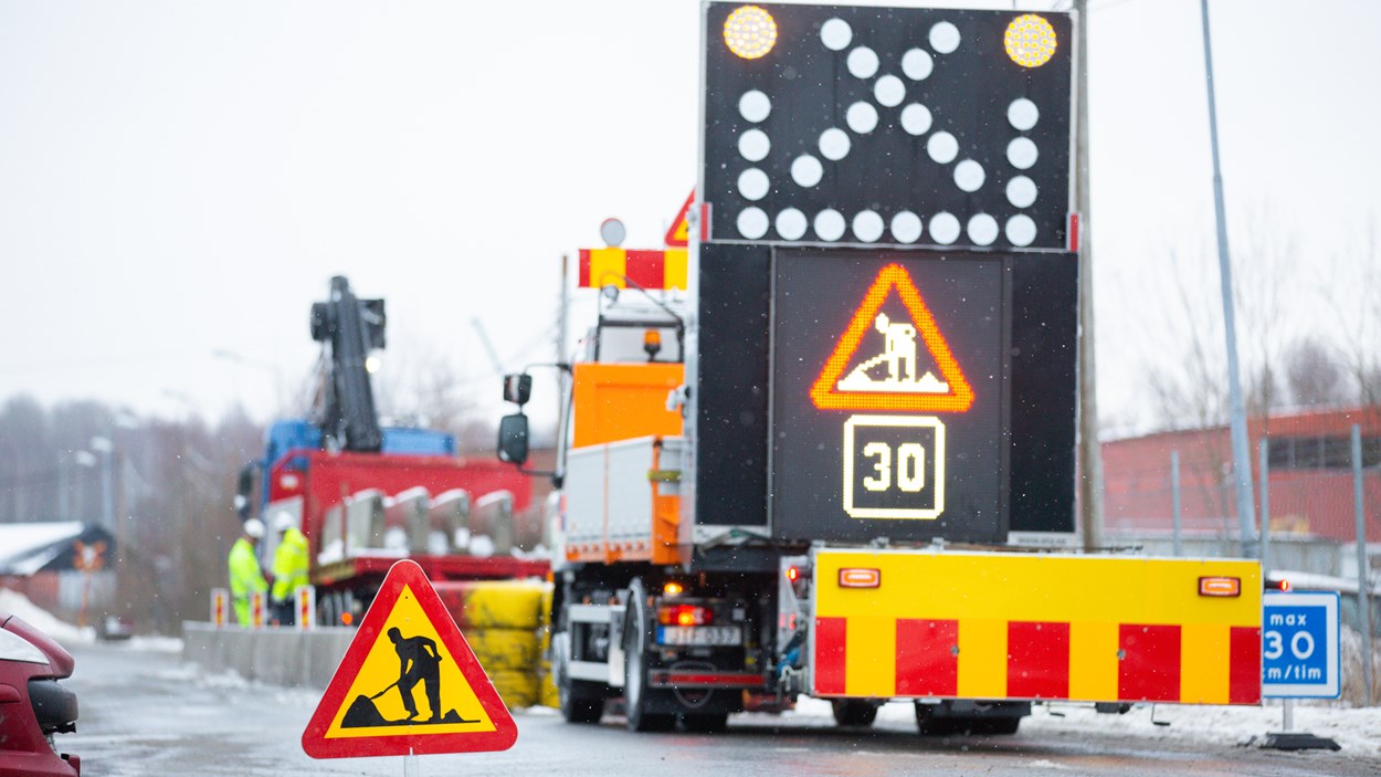 Skylt för vägarbetet pågår samt en TMA-bild med elektronisk skyt för vägarbete.