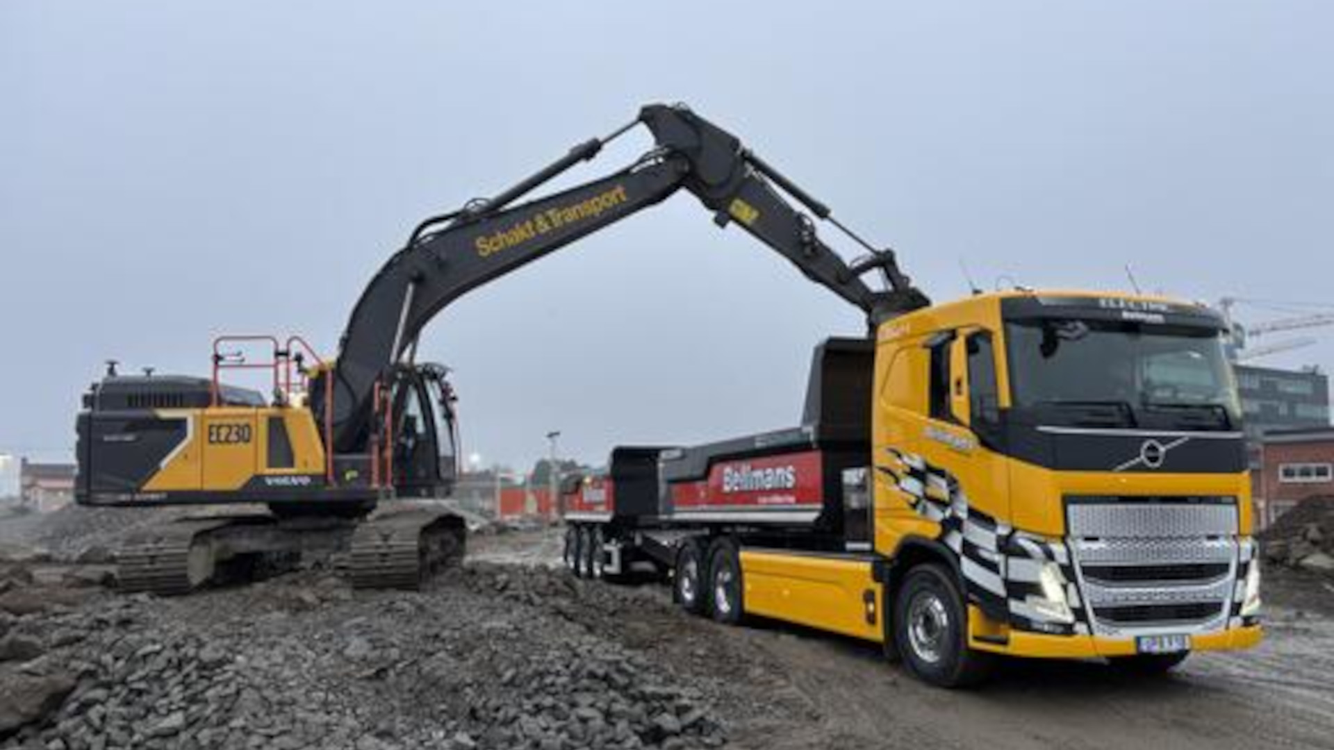 Eldriven bandgrävare lastar massor i lastbil på fossilfri byggarbetsplats i Slakthusområdet i Stockholm.