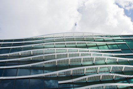 Undulating solar screens run along the lower part of the building, underscoring the water theme.