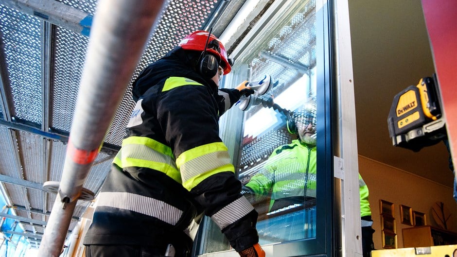 Skanskamedarbetare sätter in nya fönster under renoveringen av ett hyreshus i Trollhättan.