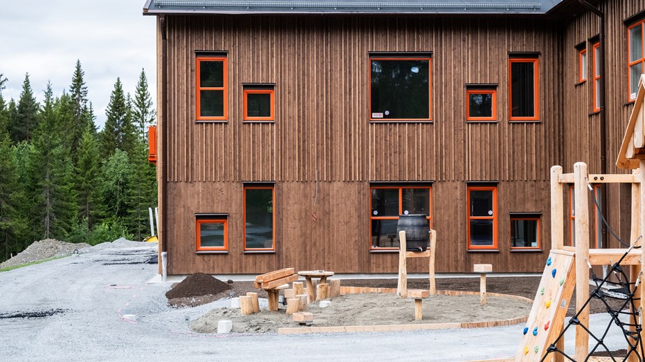 För närmiljön är de positiva effekterna med låga ljudnivåer, lägre maskinvibrationer och inga avgaslukter de mest påtagliga Fasad i brunt trä där två huskroppar möts i en hörna. Framför syns lekredskap under uppbyggnad.