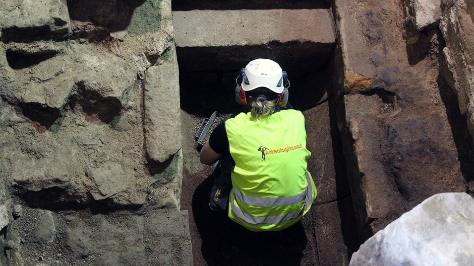 Det är Länsstyrelsen som beslutar om arkeologer ska övervaka ett byggprojekt. Här rensar arkeolog Malin Karlén fram golvet i källaren under ett av tornen på Christopher Polhems sluss från 1755. Foto: Arkeologikonsult