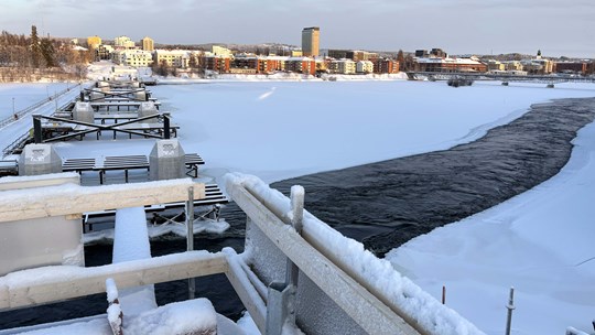 Vinterbild av brrodelar och betongperlar i isig älv.