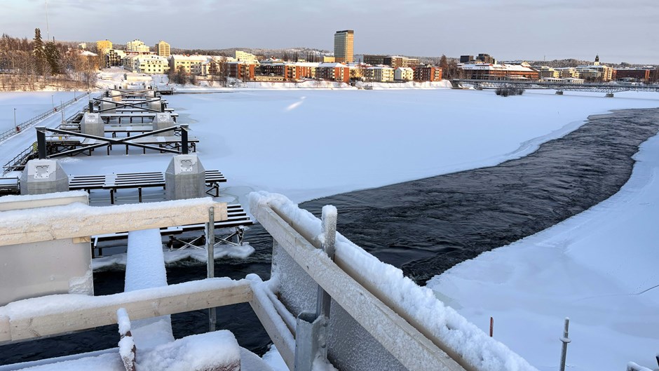 Vinterbild av brrodelar och betongperlar i isig älv.