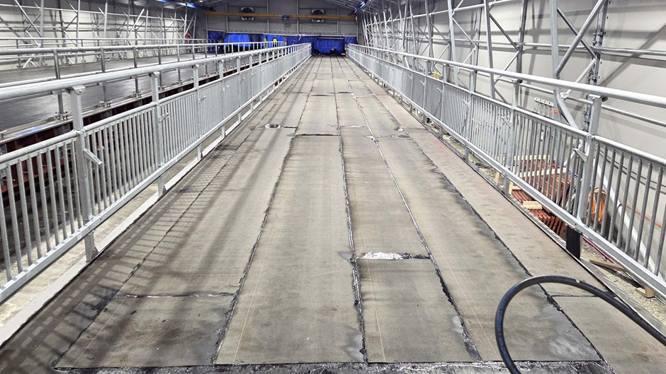 Betong brobana med grått metallstaket som bggs under ett väderskydd.