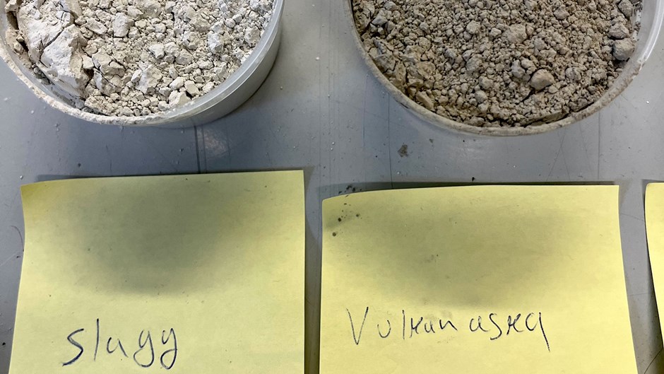 På bänken står små plastburkar som innehåller slagg och vulkanaska.
