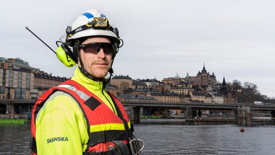 Byggarbetare står vid vattnet i Slussen i Stockholm.