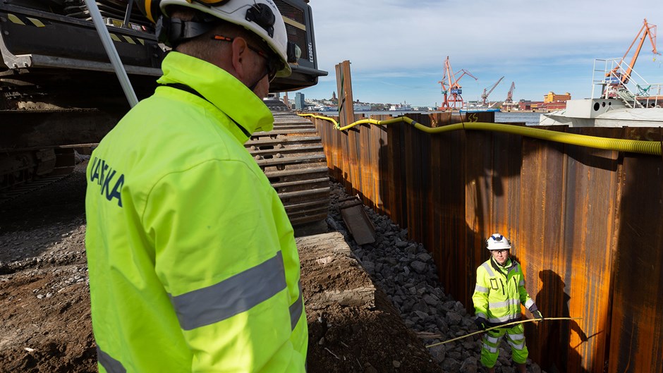 Två Skanska-medarbetare pratar med varandra på Packhuskajen i Göteborg.