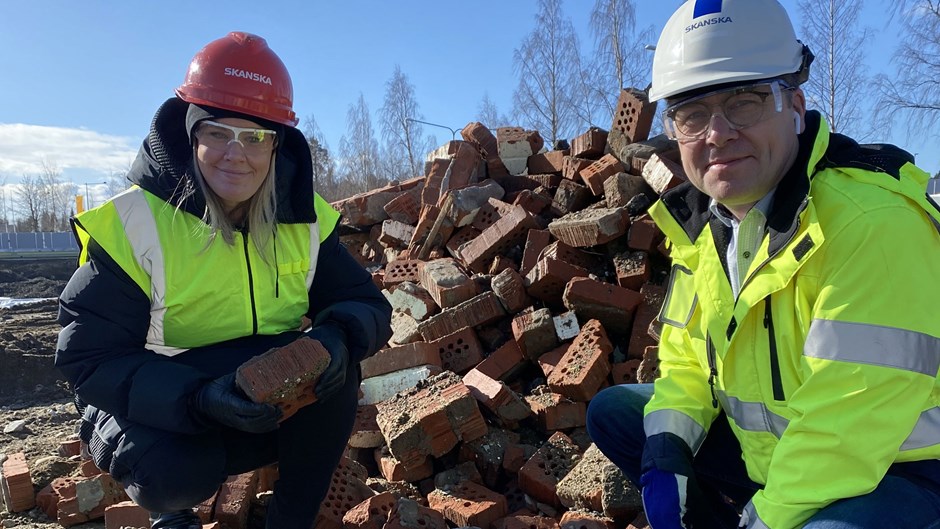 Skanska Nya Hems Anna Nordbrandt och Mats Andersson med det tegel som ska återbrukas och användas vid byggandet av gårdshuset Orangeriet.