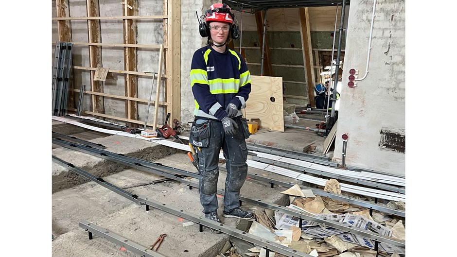 En byggarbetare står vid ett uppbrutet golv och där under ligger mängder av brev och andra dokument från sekelskiftet.