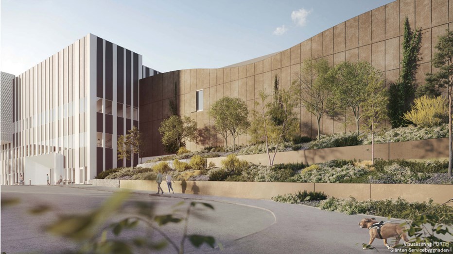 De nya byggnaderna blir en sammanhängande huskropp på cirka 24 000 kvadratmeter. Baksidan på den nya vård- och servicebyggnaden i Hässleholm med rabatter.