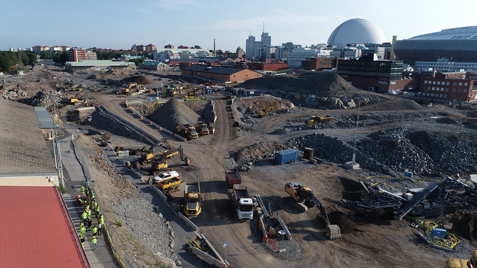 Slakthusområdet i Stockholm moOmråde med jord och kullar med Globen i bakgrunden.