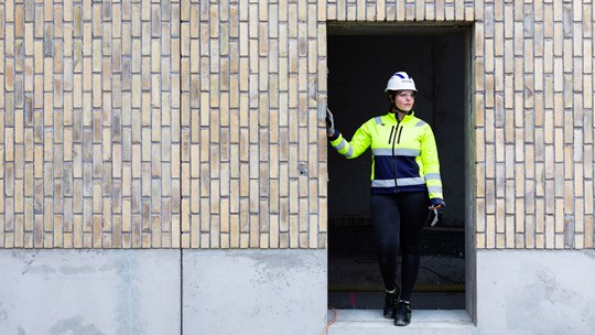 Kvinnlig yrkesmedarbetare på en byggarbetsplats.