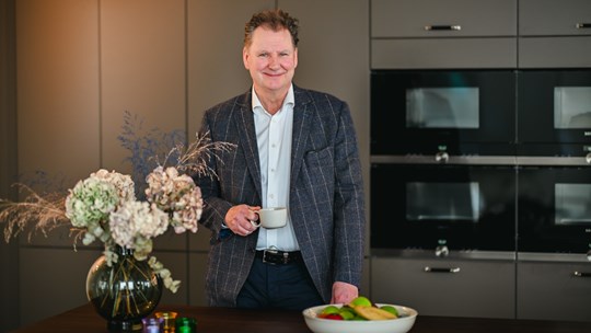 Man står intill en stor bukett blommor.