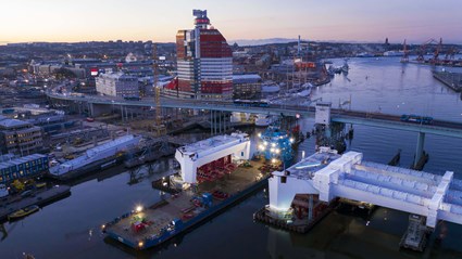 Morgonljus över arbetet med en av Hisingsbrons tvärbalkar.