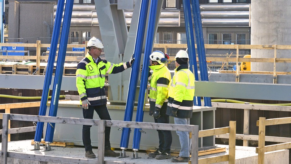 Peo Halvarsson står med två kollegor på projektet Hisingsbron med skyddskläder och kollar på konstruktionen.