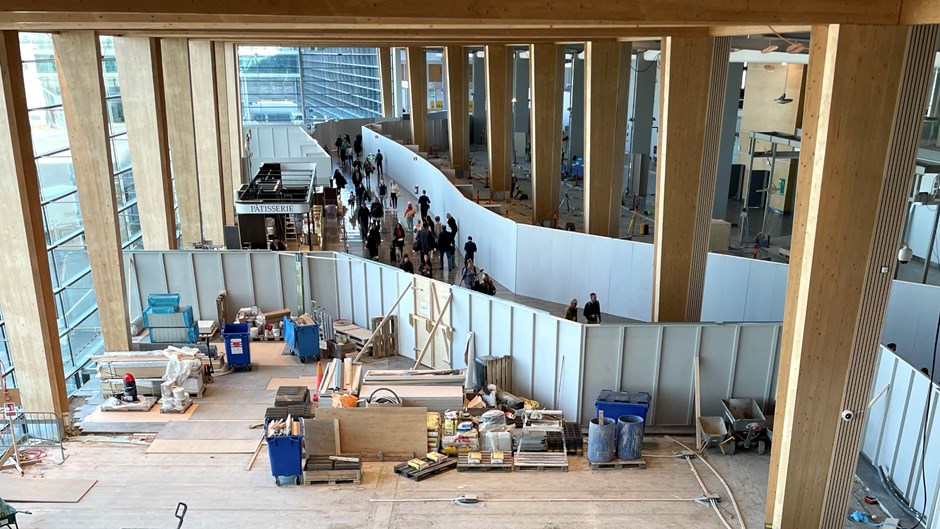 Byggarbetsplats på Arlanda där resenärerna passerar utanför byggplanket.
