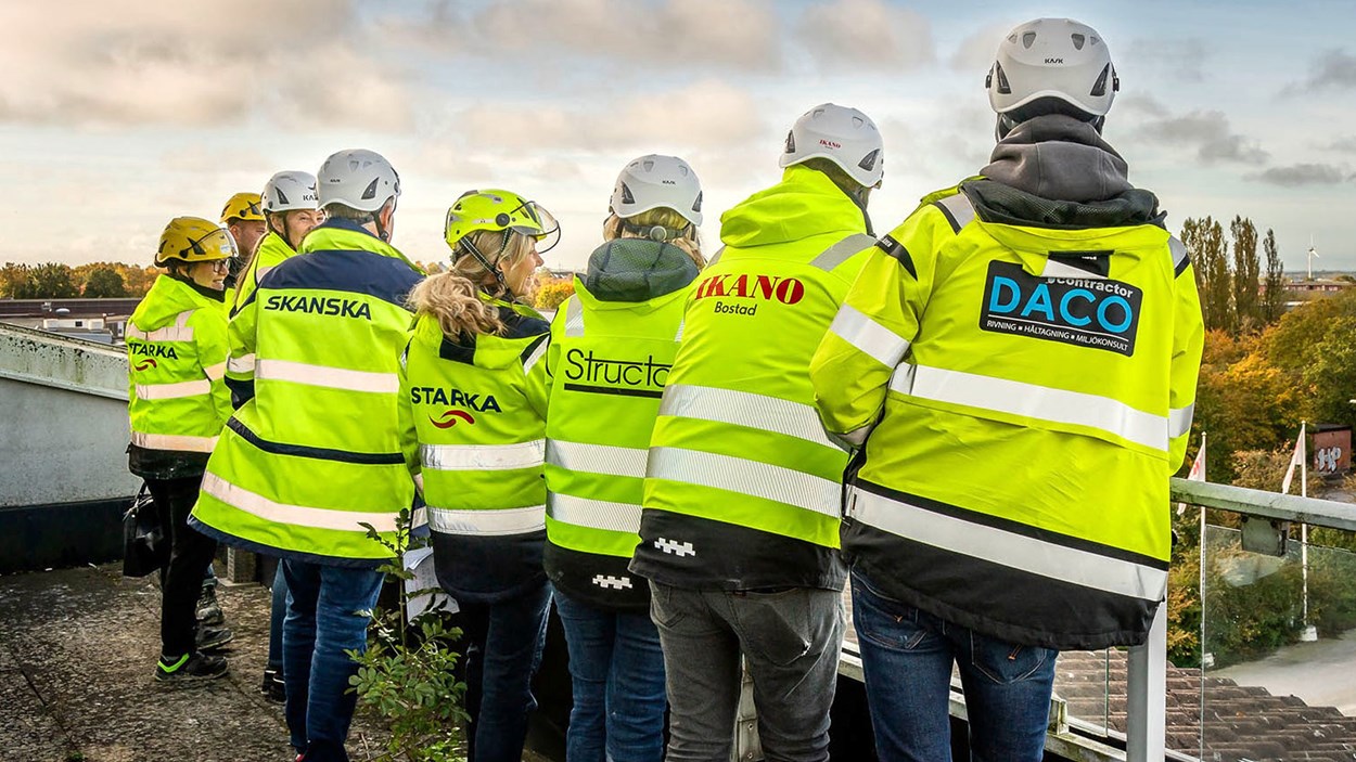 Medarbetare från Skanska, Ikano Bostad, Starka Betong, Daco och Structor står på rad med ryggen mot kameran.