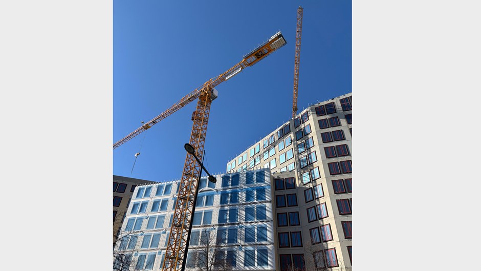 Betongväggar och byggkranar mot en blå himmel.