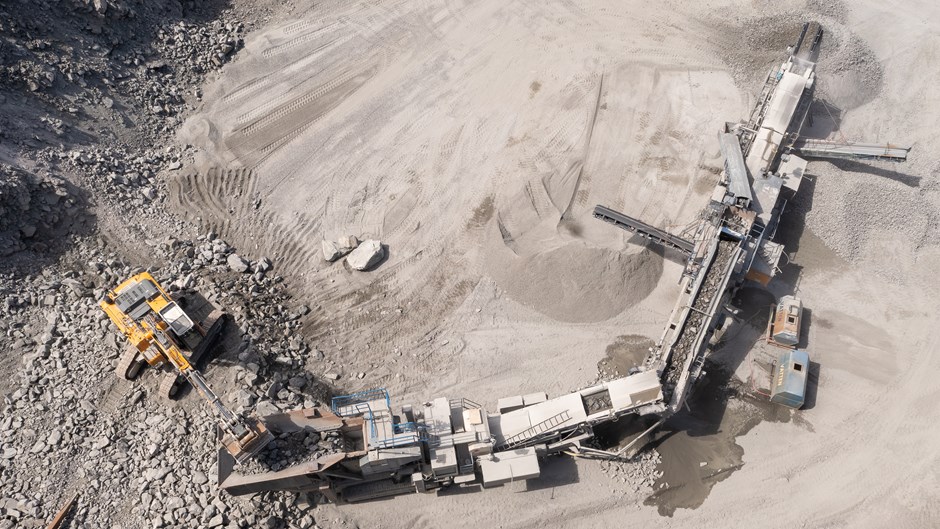 Flygbild över Ale Resurspark med grävmaskiner och stora jordhögar.