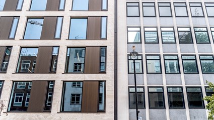 The cladding on Berners Mews used Travertine Stone and bronze profiled panels, as well as bronze punch hole windows.