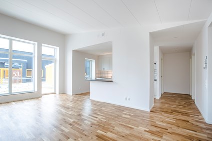 Stora fönster och högt i tak i vardagsrummet skapar ljus och rymd.