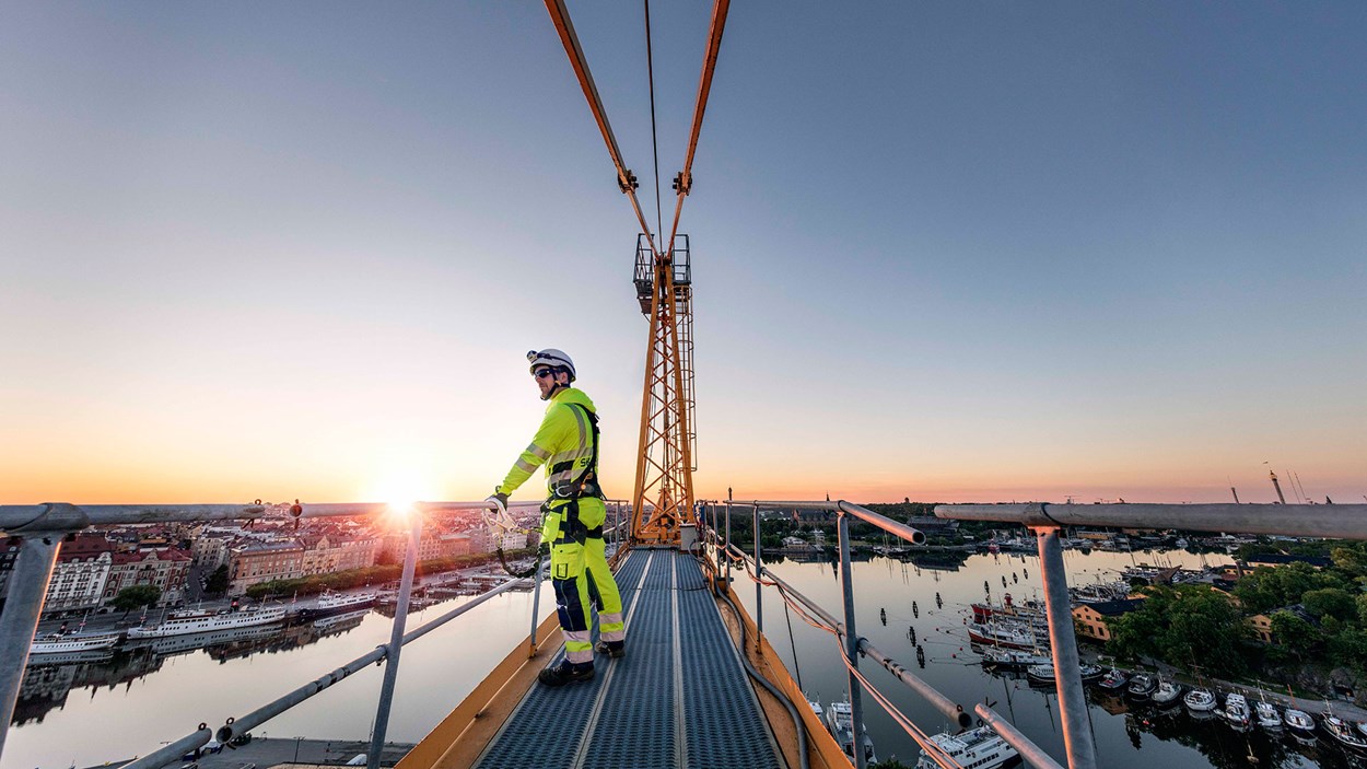 A man who works high on a scaffolding with a great view