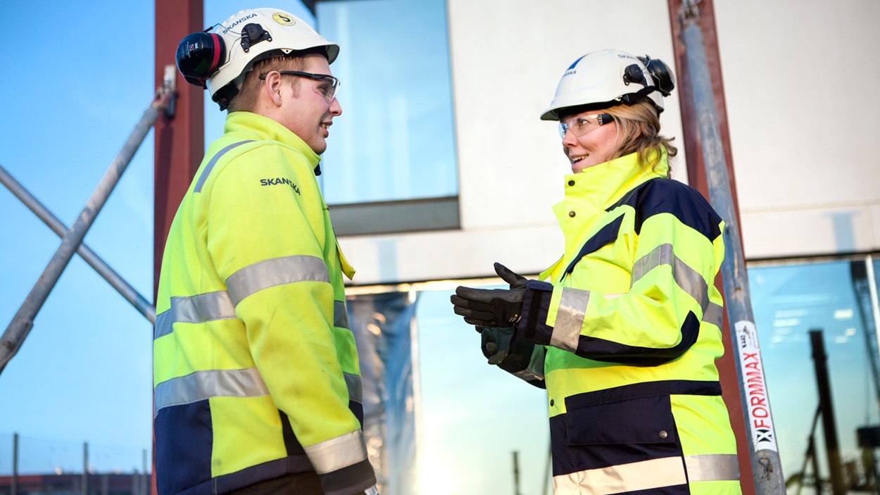 Collegues with helmets talking to each other