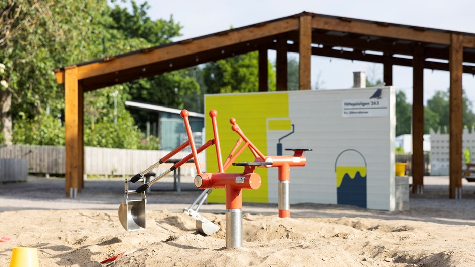 Röd grävmaskin i Täby Lekpark.
