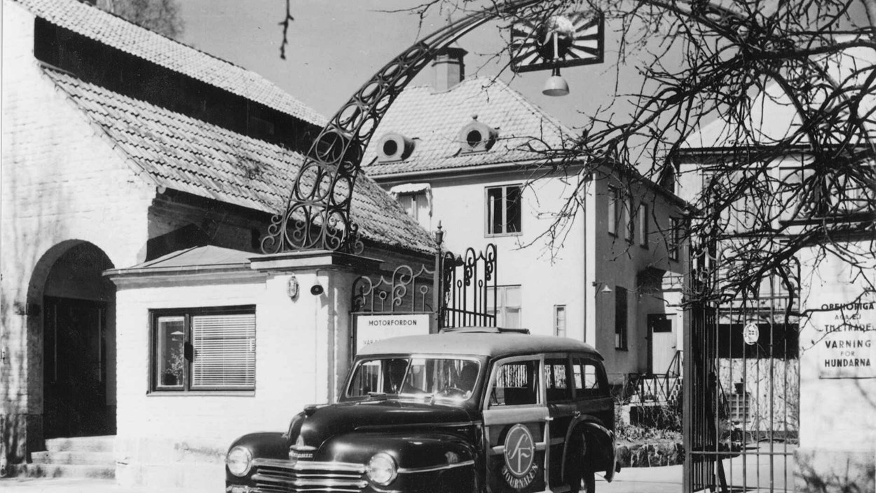 Svartvitt foto av en entrén med en båge som bär namnet Filmstaden.  I förgrrunden står en tidstypisk bil med SF-skylt på dörren. Foto Filmstaden Kultur