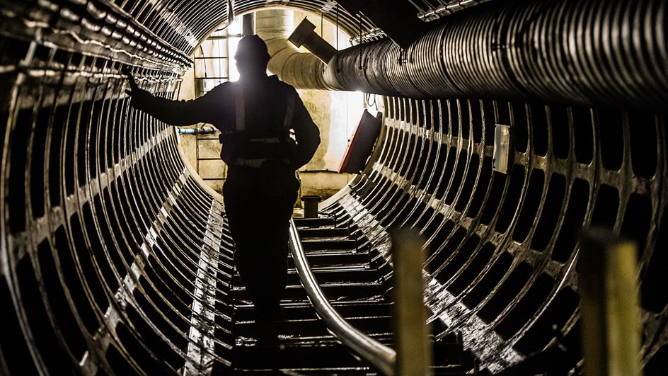 Person som står i en mörk tunnel med ljus bakifrån.