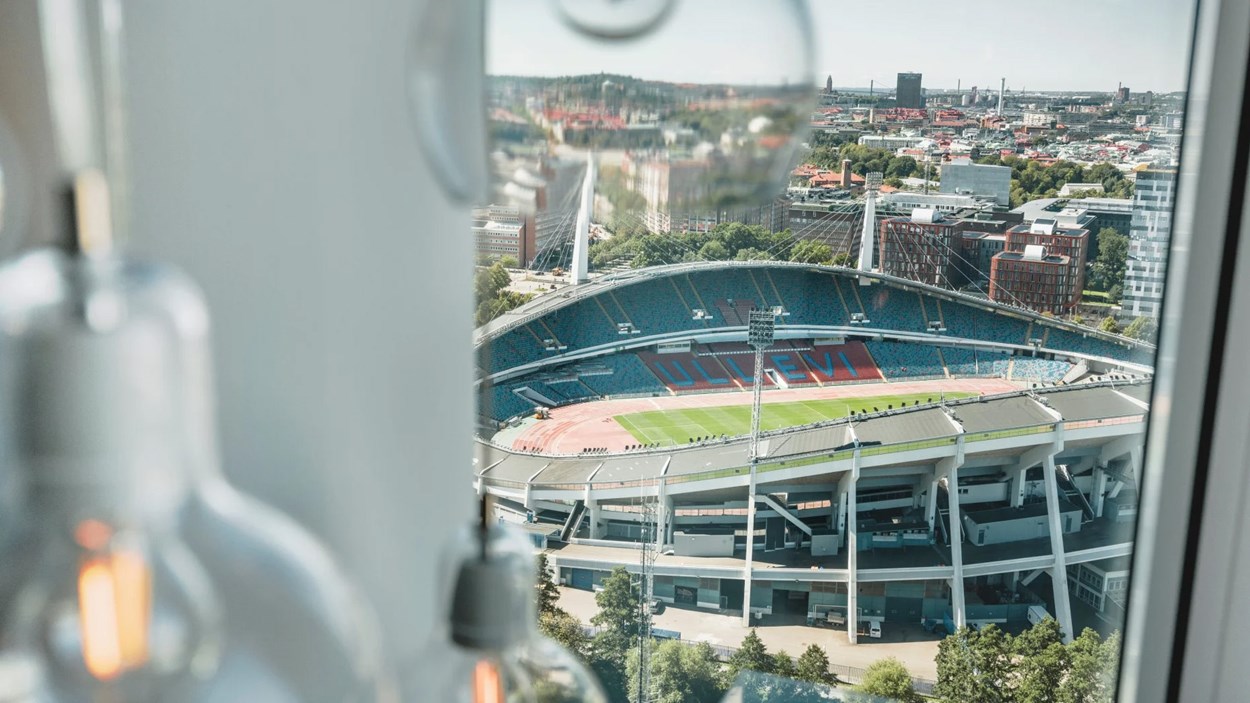 Utsikt från ett fönster högt upp över en idrottsarena.