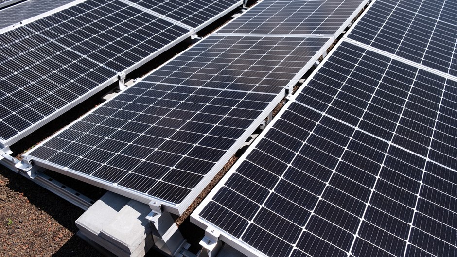 Solen blänker i en svart solpanel som laddas med energi.