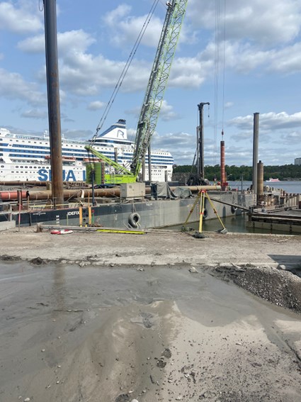 Large ferries dock adjacent to the worksite.