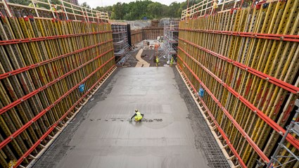 Betongen beräknas minska koldioxidutsläppen med minst 40 procent. Betongbil och kranar parkerade vid arbetsplatsen.