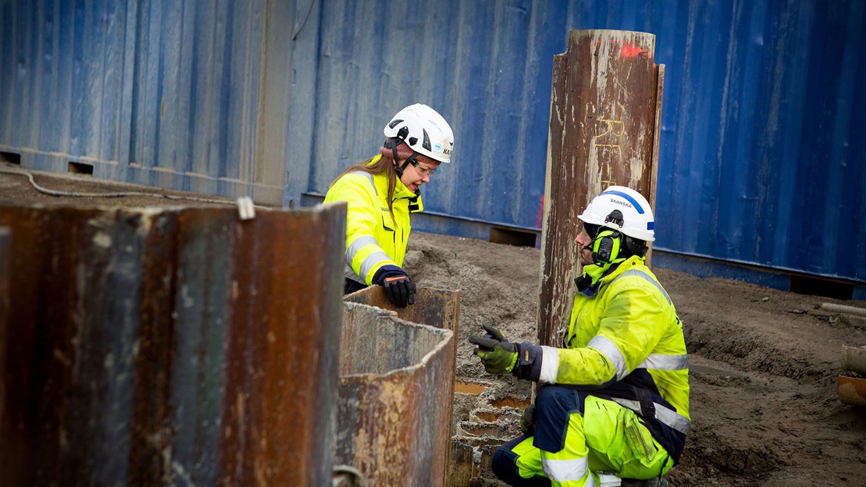 Two workers inspecting the piling at a worksite.