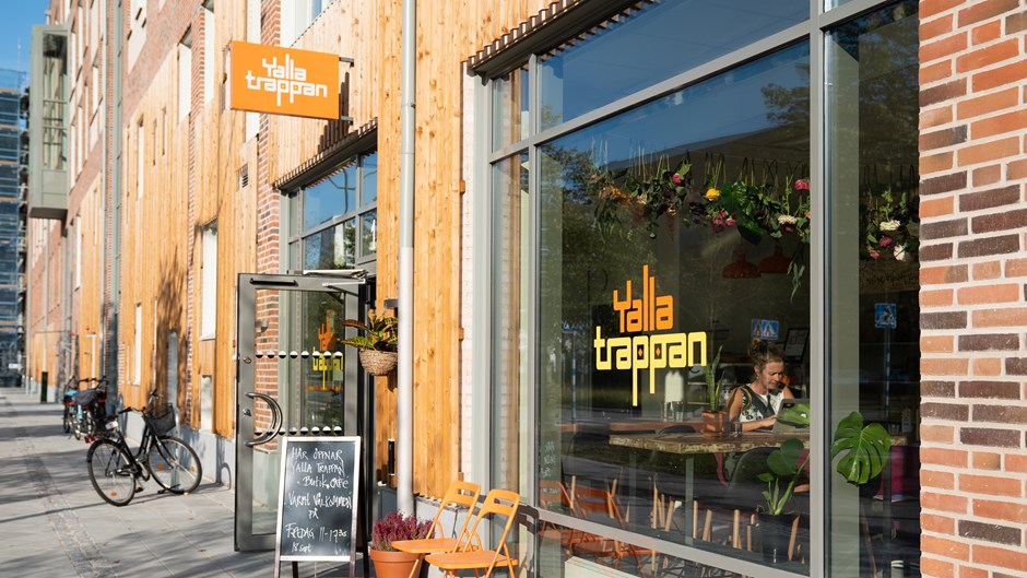 Utanför Café Yalla Trappan står några stolar och en skylt med texten ”Här öppnar Yalla Trappan Butik & Café”. 