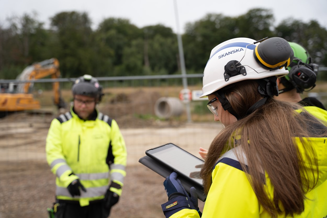 Kvinna med läsplatta på byggarbetsplats