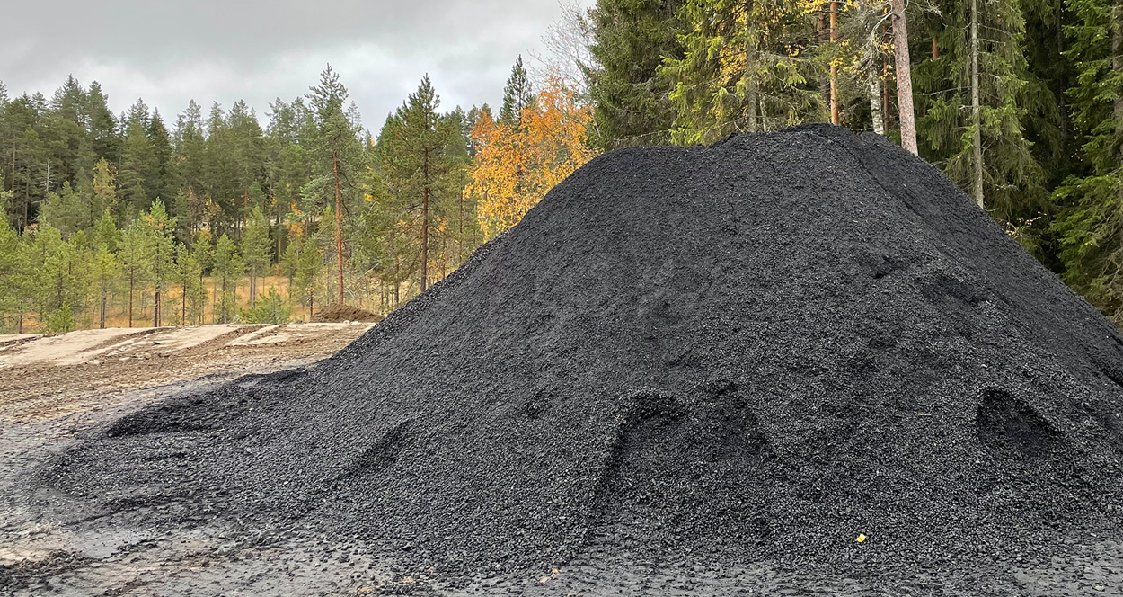 Biokol i en hög med skog i bakgrunden