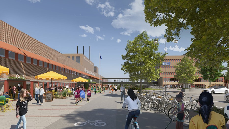 Den gamla byggnaden för Pripps Bryggeri görs om till idrottscentrum. Fastigheten klassas som kulturhistoriskt värdefull och kommer till det yttre att bevaras samt att även inre delar av byggnaden i viss mån blir kvar. Visionsbild från White Arkitekter Rendering med huslänga till vänster i tegel och rakt fram ytterligare en brun tegelbyggnad. På den öppna ytan finns träd och människor som rör sig samt bord med parasoller.