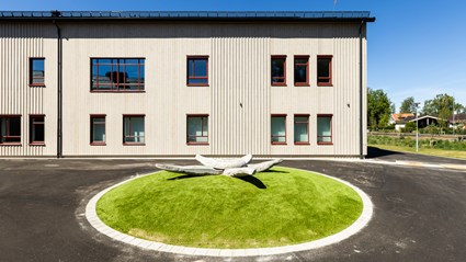 Fasad i värmebehandlad furupanel och röda fönsterdetaljer ger skolan ett varmt och naturligt uttryck.
