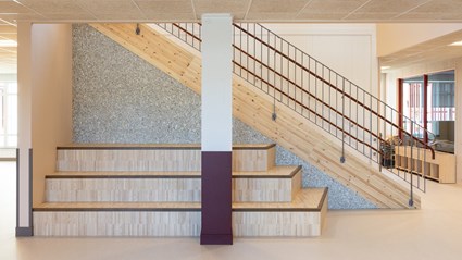 Trappan kombinerar massivträ och väggpanel av återvunnet material, ett tydligt exempel på hållbarhet.