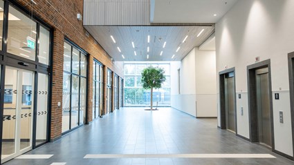 The hospital is bright, featuring large window sections at the entrance.