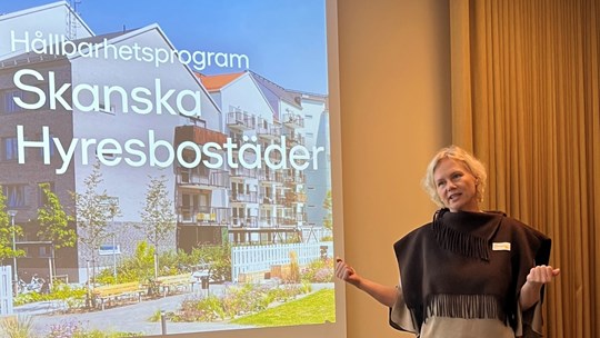 Kvinna föreläser framför en filmduk.