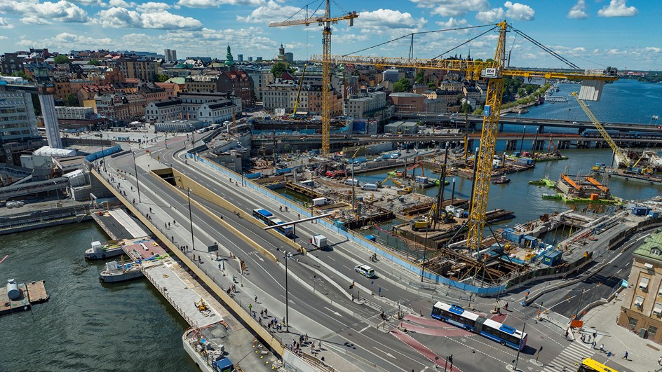 Slussen från ovan med bussar som trafikerar bron och byggkranar i Saltsjön intill.