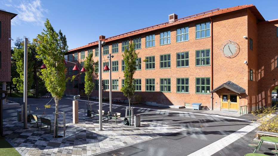 Den stora klockan på fasaden visar tydligt tiden. Hästhagsskolans skolgård med en stor klocka.