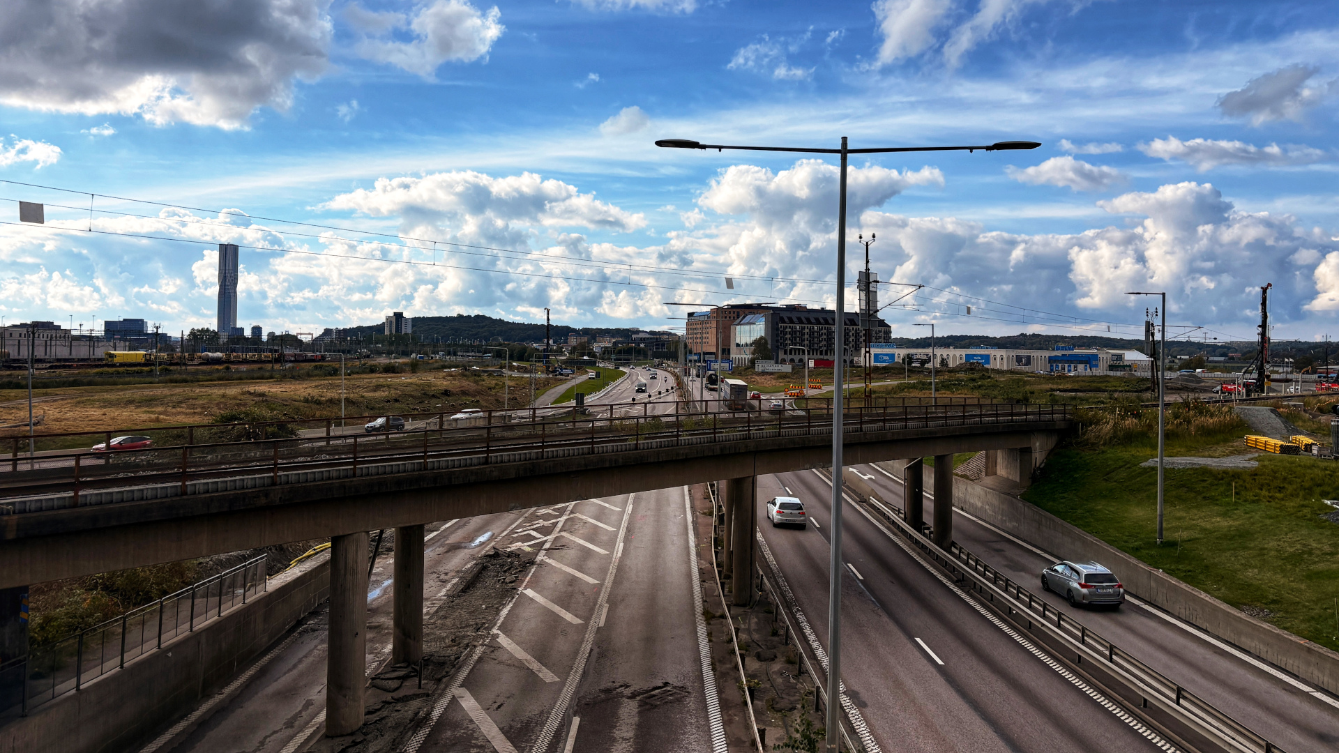 Lundbyleden i Göteborg med trafik och Karlatornet i bakgrunden, vy mot stadens centrum.