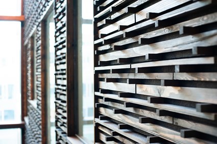 Träpanelen på atriets väggar är gjord av uttjänta fönsterramar och träbalkar från Skanskas rivningsprojekt i Nyhamnen.