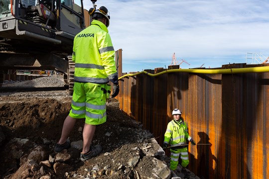 Två byggarbetare pratar med varandra i projekt Packhuskajen i Göteborg.